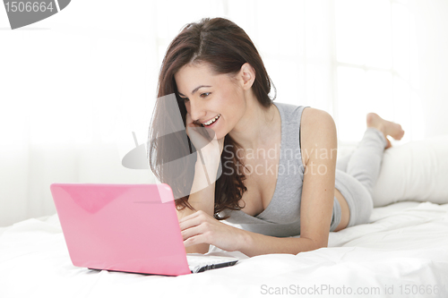 Image of Pretty girl smiling at her computer typing