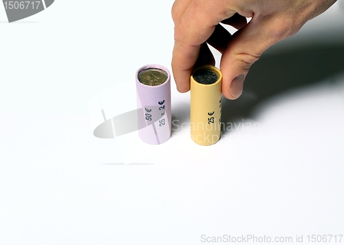 Image of Hand grabbing a Euro coin roll