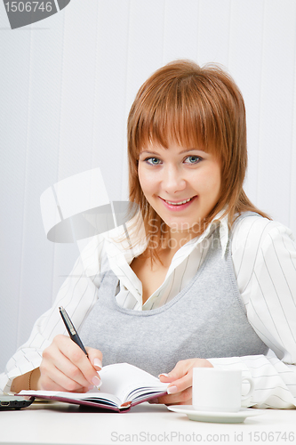 Image of smiling attractive girl with a notebook