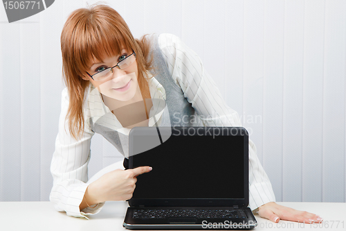 Image of girl with glasses shows a finger on a laptop