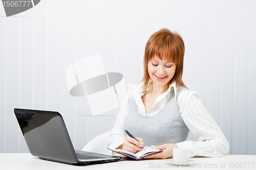 Image of smiling attractive girl with a notebook