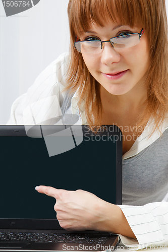 Image of girl with glasses shows a finger on a laptop