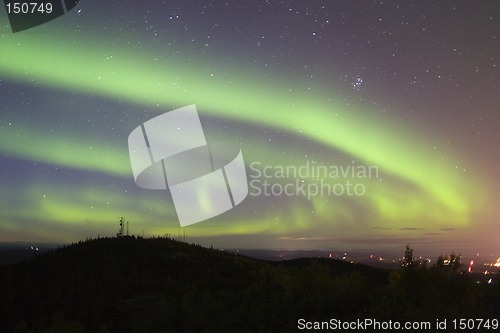 Image of Aurora swirling over town