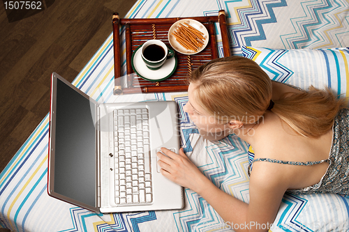 Image of woman in bed with laptop