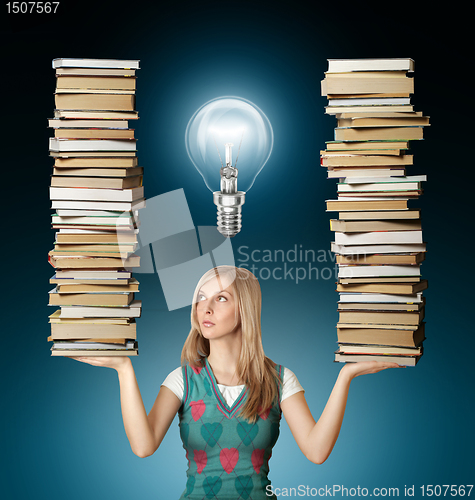 Image of woman with many books in her hands and bulb