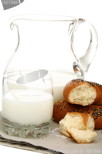 Image of Bagel with poppy seeds a pitcher of milk.