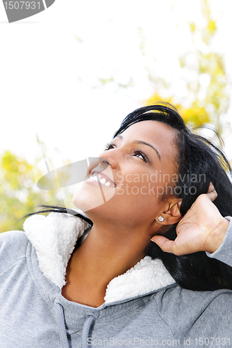 Image of Smiling young woman outdoors looking up