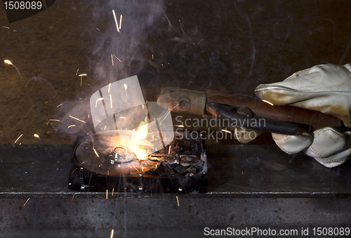 Image of welding on open hard disk drive in dark rusty background