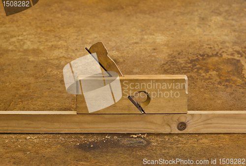 Image of planer on wood in rusty background