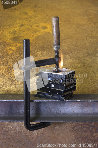 Image of clamp pressing on stack of hard drives