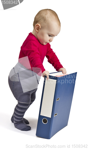 Image of small child standing next to blue ring binder