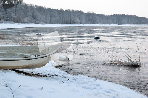 Image of Winter landscape with a fishing boat on seacoast