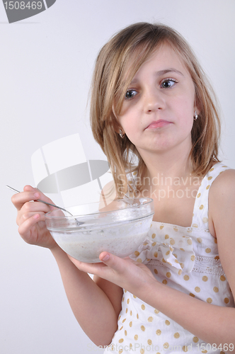 Image of thoughful child with a bowl of milk porridge