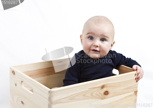 Image of toddler in wooden box