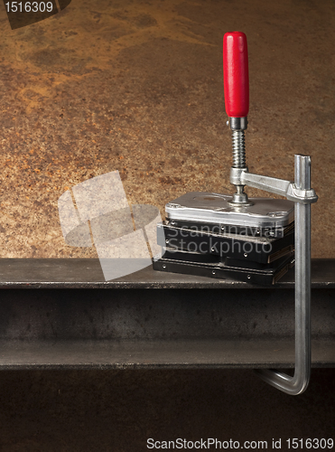 Image of three hard drives pressed together with a clamp