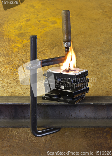 Image of burning hard drives compressed with clamp