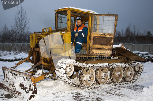 Image of The tractor driver cleans snow