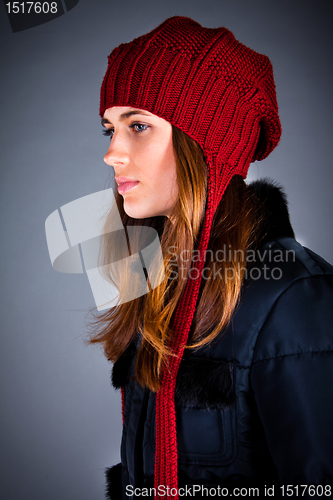 Image of Portrait of the young girl in a winter cap on the dark