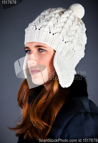 Image of Portrait of the young girl in a winter cap on the dark