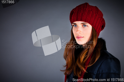 Image of Portrait of the young girl in a winter cap on the dark