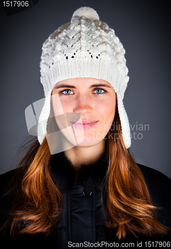 Image of Portrait of the young girl in a winter cap on the dark