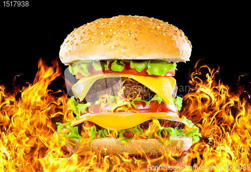 Image of Tasty hamburger on fire on a dark