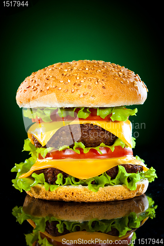 Image of Tasty and appetizing hamburger on a darkly green