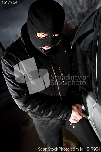 Image of robber and the thief in a mask hijacks the car