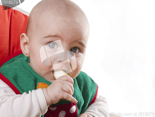 Image of baby sitting and eating an apple