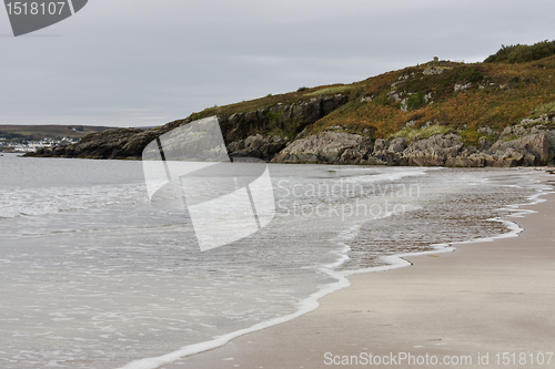 Image of sandy coastline with hill in background