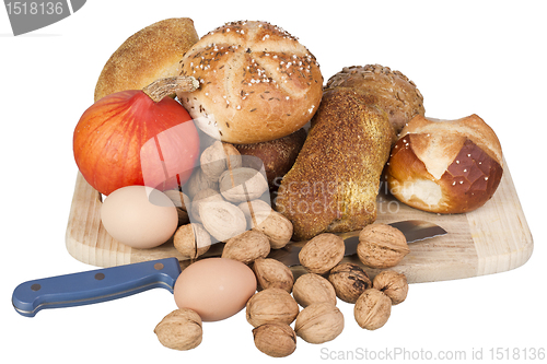 Image of gem, nuts, eggs and a pumpkin on a wooden board