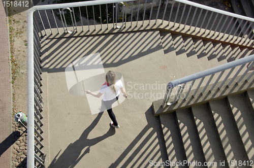 Image of Girl setting downstairs railings sunlight shadows