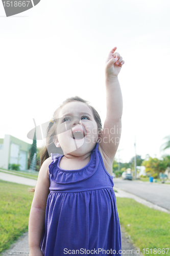 Image of happy little girl three years old signing the sky