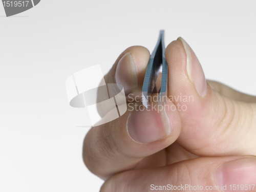 Image of hand and tweezers