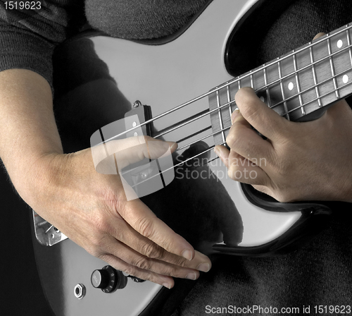 Image of hand on bass guitar