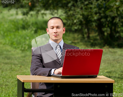Image of man with laptop working outdoors