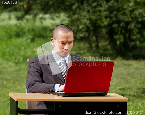 Image of man with laptop working outdoors