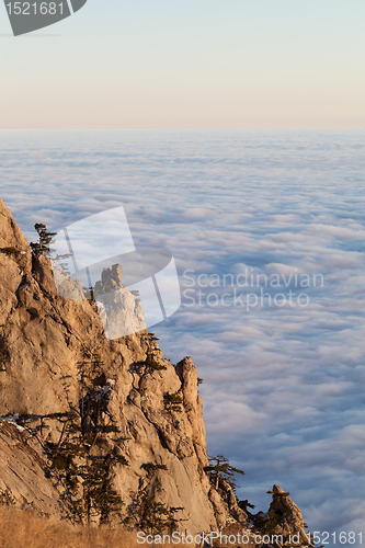 Image of Sunlit cliffs and sea in clouds