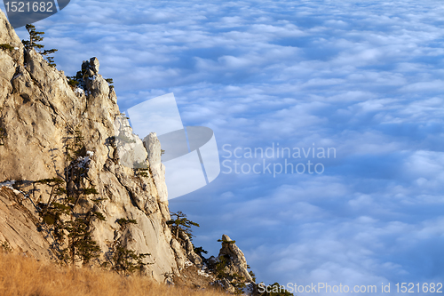 Image of Sunlit cliffs and sea in clouds