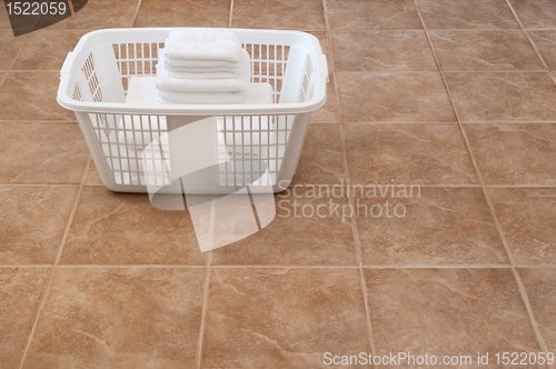 Image of White towels stacked in a laundry basket