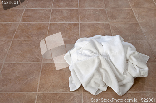 Image of Creased white towels on ceramic floor