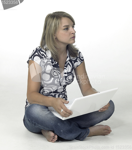 Image of cute blonde computing girl - contemplative