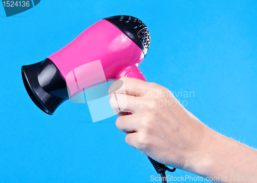Image of Pink hair dryer in the female hand