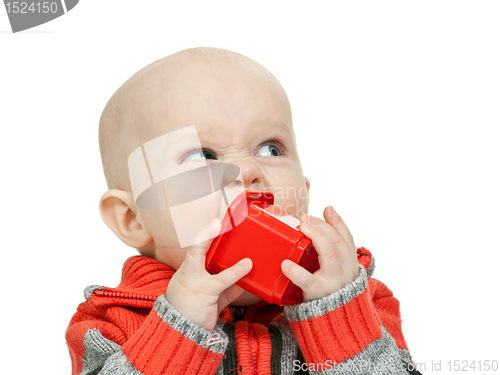 Image of little boy chewing on a plastic pyramid in the studio