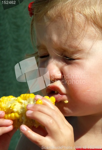Image of litle girl eating corn on the cob