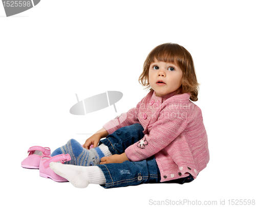 Image of little girl wears shoes on a white floor