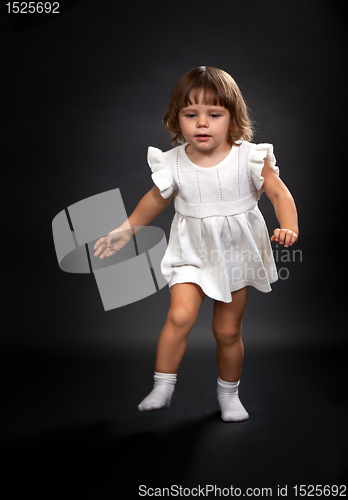 Image of the first steps of a little girl on a black background.