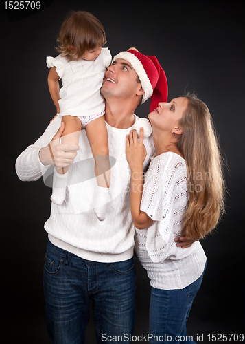 Image of family on a black background, Santa's hat with dad.