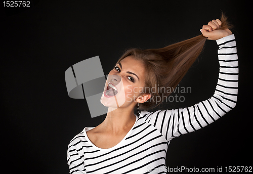 Image of Beautiful girl in a striped dress pulls his hair