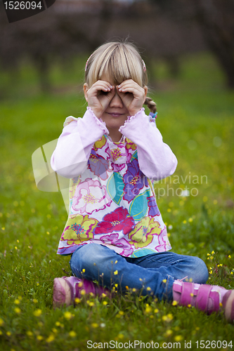 Image of Little girl outdoors with imaginary binoculars